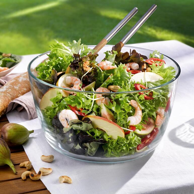 Dankzij de uitneembare draaimand serveert u de gespoelde sla direct in de elegante schaal van kristalhelder borosilicaatglas. Kom met verse salade op een tafel in de openlucht.