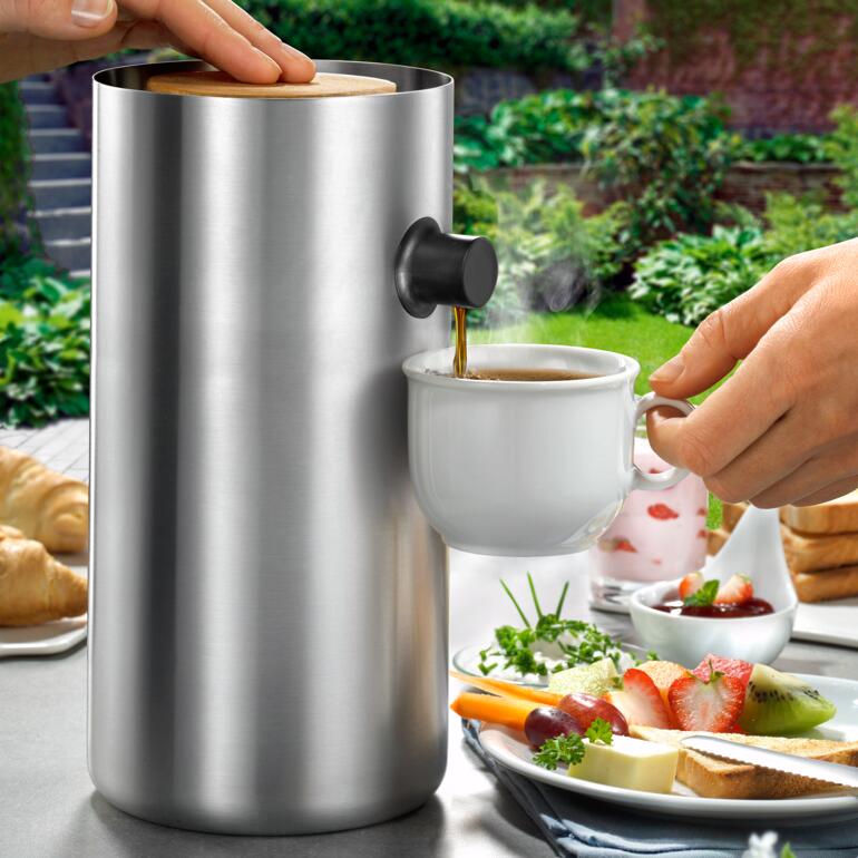 Design-pompkan uit roestvrij staal naast een koffiekopje.