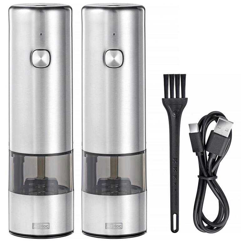 Twee accu-pepermolens met USB-oplaadkabel en borstel naast elkaar.