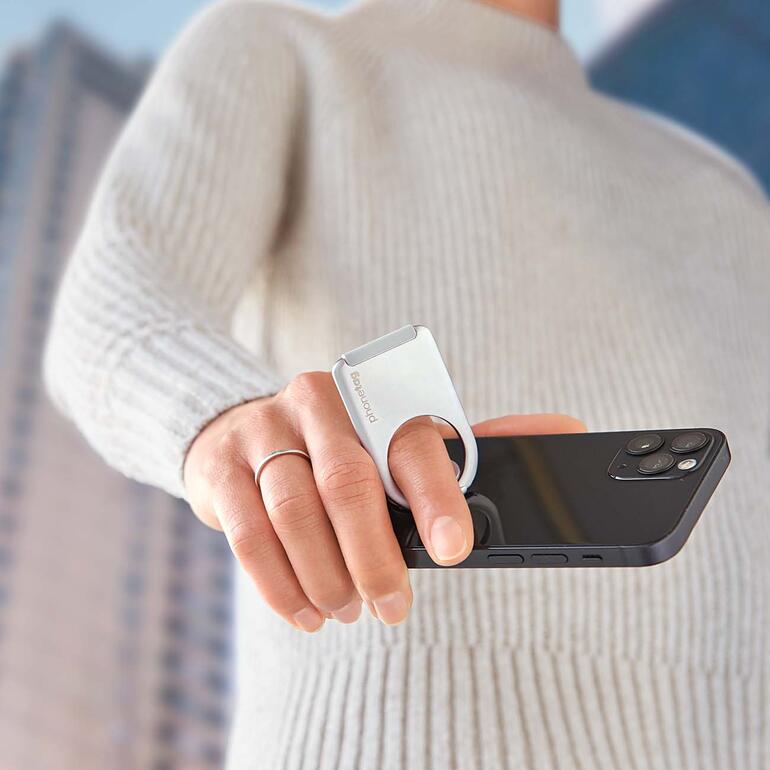 Om te bellen, te lezen of te typen, hebt u uw smartphone altijd veilig en ontspannen in de hand. Persoon houdt smartphone vast met ringhouder.