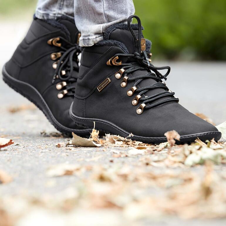 Met deze warme hoge veterschoenen geniet u ook op koude dagen van het bijzonder vrije, natuurlijke loopgevoel – in het dagelijks leven, tijdens het shoppen, citytrip, boswandeling, ... Zwarte winterlaarzen met gouden details en veters op een grijze ondergrond.