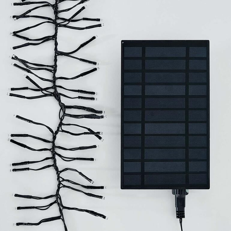 Uitbundige verlichting, gevoed door een zeer efficiënt zonnepaneel. Zonne-lichtsnoer en zonnepaneel op een witte achtergrond.
