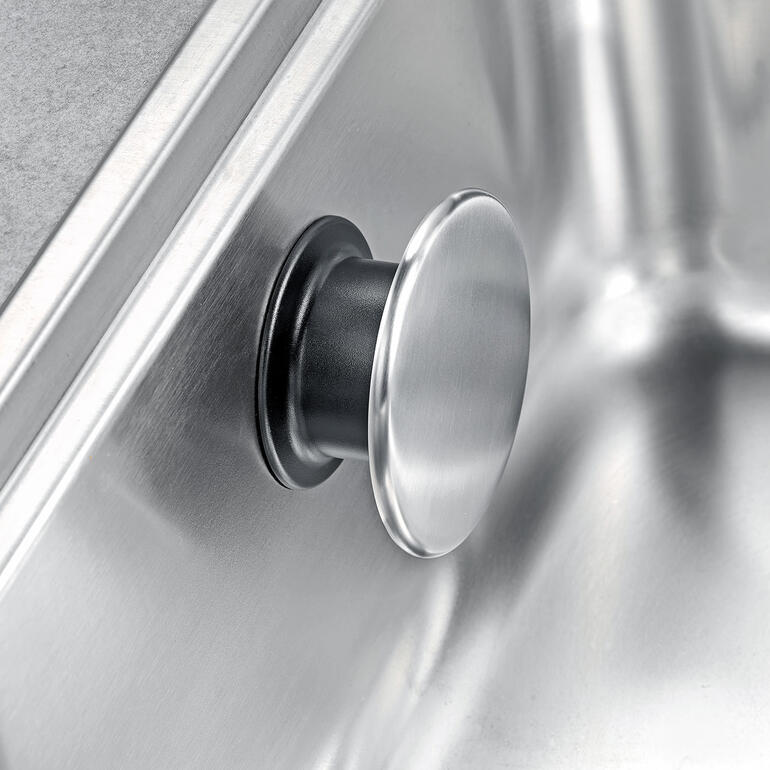 Snel bevestigd: gewoon kort aandrukken, aan de edelstalen knop draaien, klaar. Detailopname van de design vaatdoekhouder met metalen afwerking.