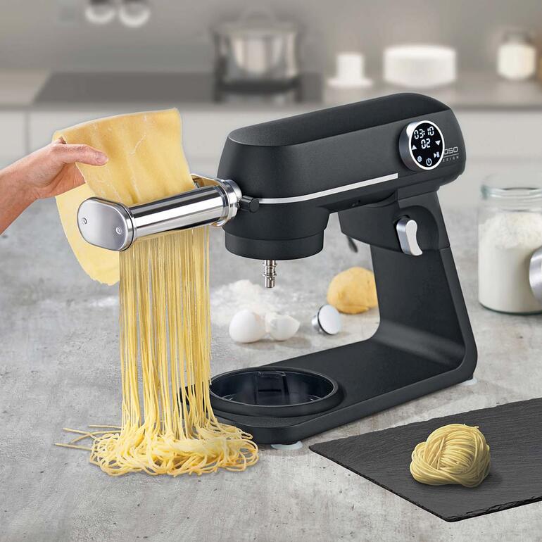 Spaghetti snijder in actie op een keukenmachine met vers deeg.