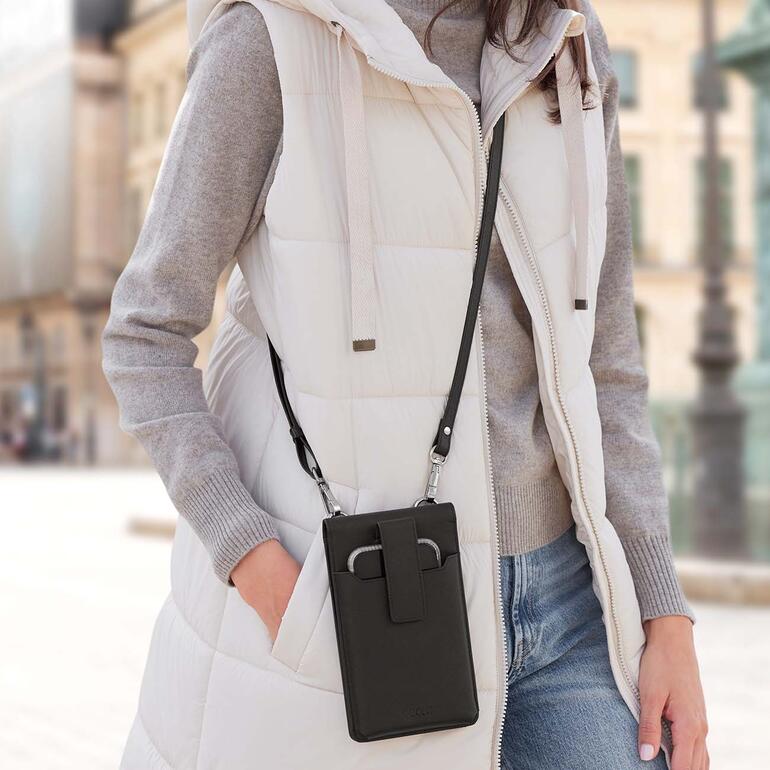 Vrouw draagt een zwarte crossbody-smartphone tas.
