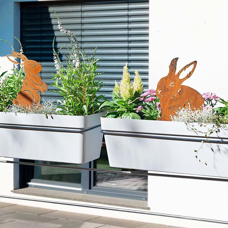 Konijnen tuinprikkers in bloempotten op een balkon gedecoreerd.