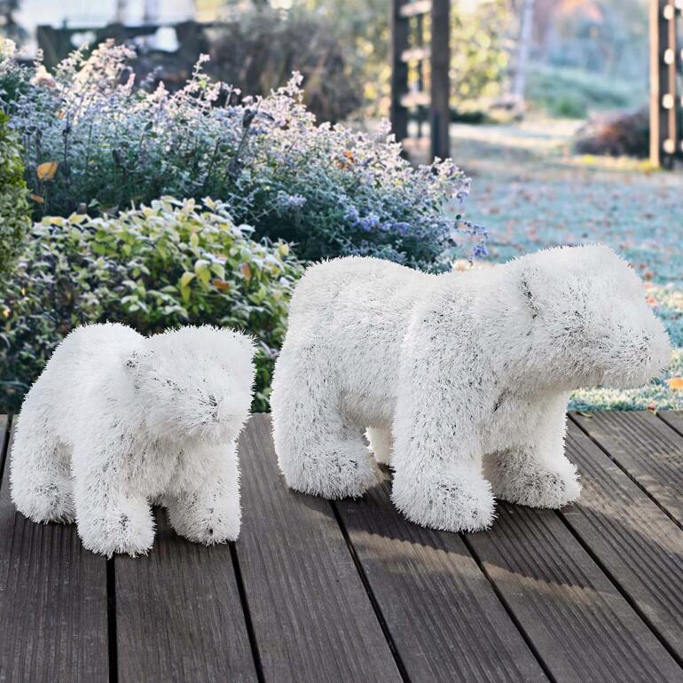 Twee pluizige ijsberen van synthetisch materiaal op houten vloer.