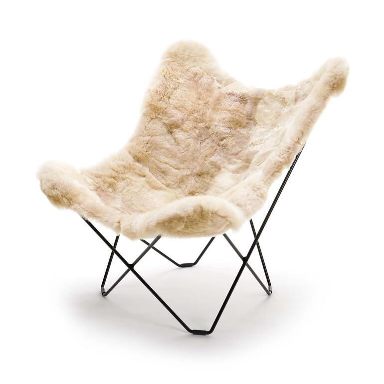 De rug van de stoel heeft een royale breedte en hoogte – aangenaam zitcomfort, ook voor grotere personen. Mariposa alpaca lounge stoel zonder bezette persoon, minimalistisch.