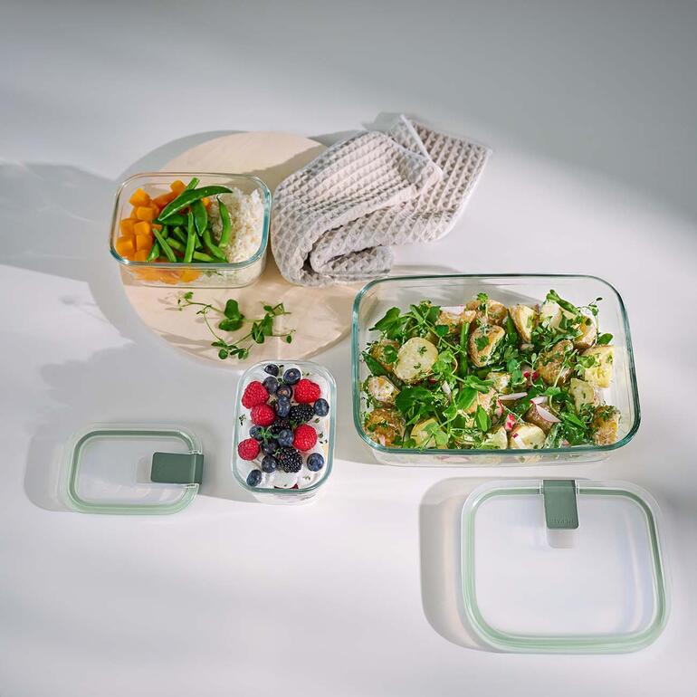 Ook ideaal voor het bakken, gratineren, serveren, ... Diverse glazen vershoudboxen met voedsel op een tafel.
