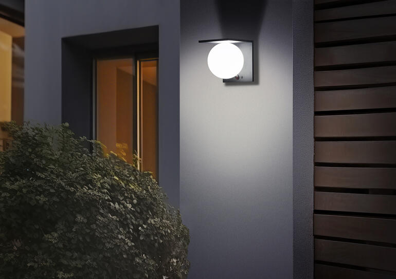 Zonnebollenwandlamp verlicht zacht op een muur.