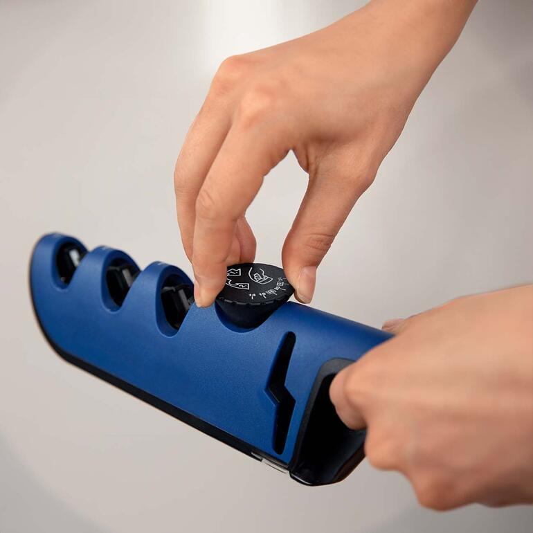 Met de draaiknop stelt u de individueel gewenste slijphoek in (aanbevelingen meegeleverd*). Hand van een gebruiker die de slijper aanpast met een draaiknop