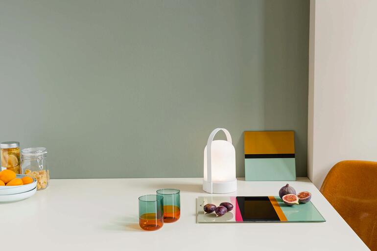 Accu-lampen Piccolos en Grande op een tafel met kleurrijke glazen.