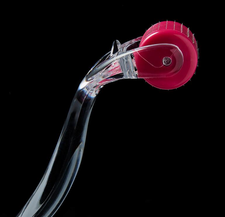 192 ultrafijne, met de hand geplaatste naaldjes van chirurgisch staal met zilvercoating dringen door in de verhoornde bovenste huidlaag en verwijderen de afgestorven cellen. Close-up van Beautyroller® 2.0 met een roze roller.
