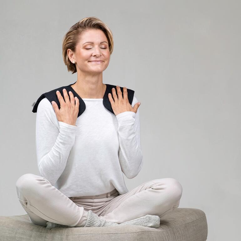 Vrouw met moorkussen op haar schouders, ontspannen