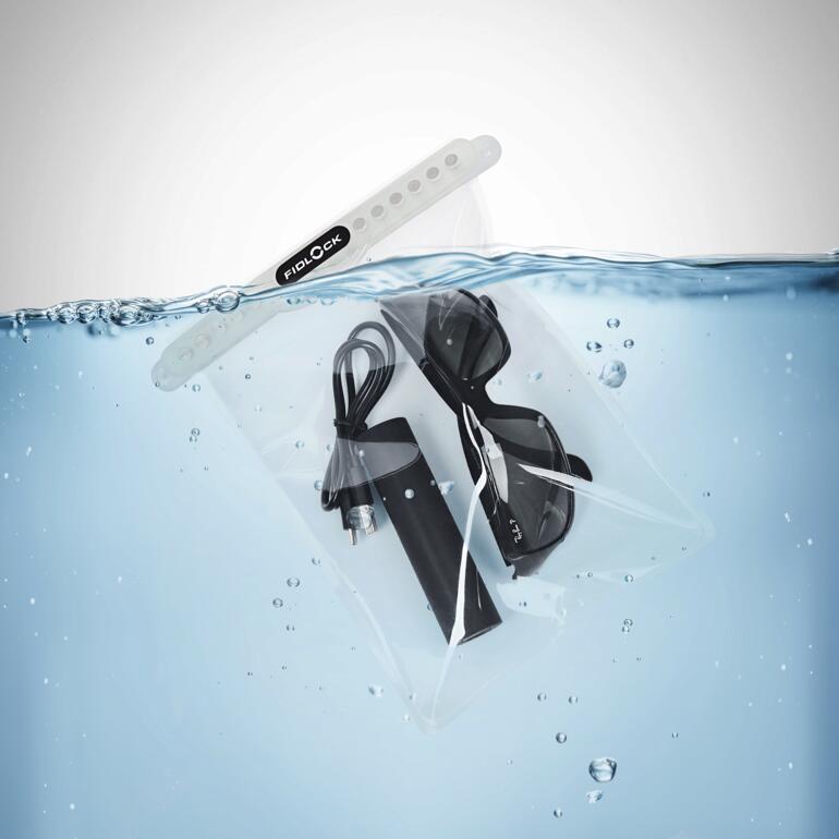 Transparante dry bag met een kabel en een bril in het water.