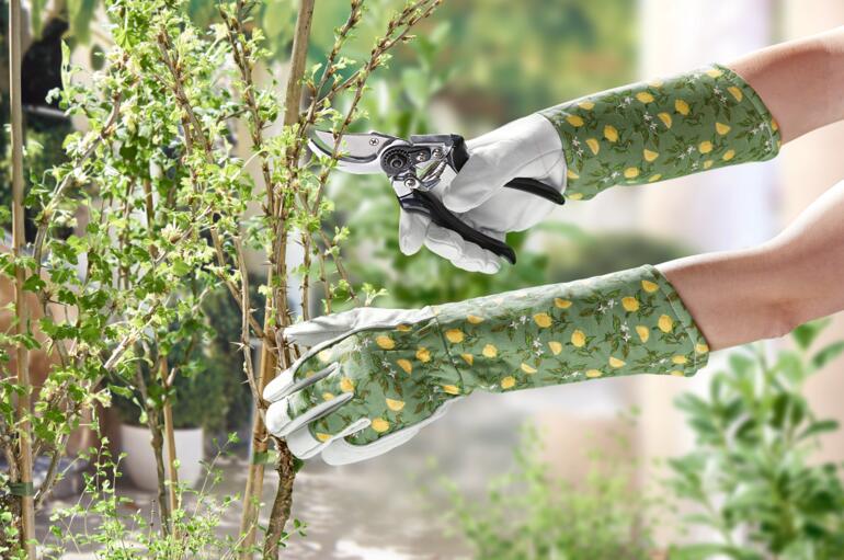 Dames tuinhandschoenen met snoeigereedschap in de hand