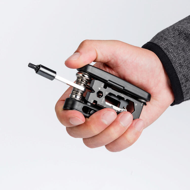 Met de solide 30-in-1 tool is bijna elke fietsreparatie mogelijk. Man houdt compact 30-in-1 fietsgereedschap in zijn hand
