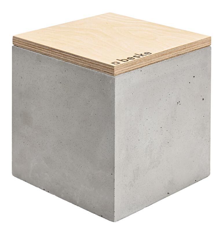 Betonnen kubus inclusief vulling van was en los deksel met origineel Beske-stempel. Handgemaakt betonwaslicht met houten deksel op lichte achtergrond.