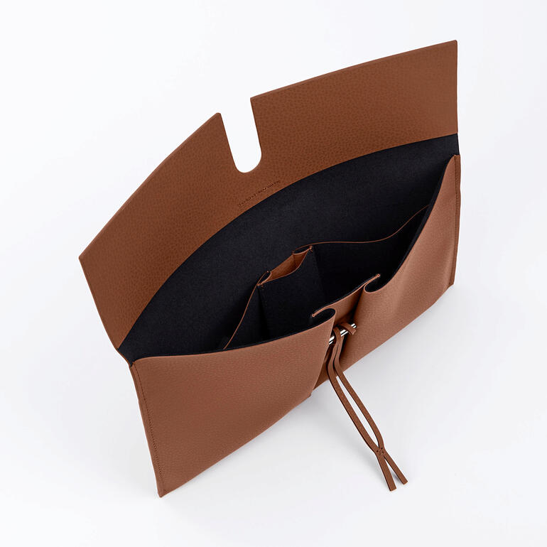 Heel kenmerkend voor de collectie van de succesvolle tweelingzussen is het duidelijke lijnenspel en de enorme liefde voor detail – zoals de geraffineerde manier waarmee de clutch gesloten kan worden. Binnenkant van de Reto Mirum® clutch met vakken en rits