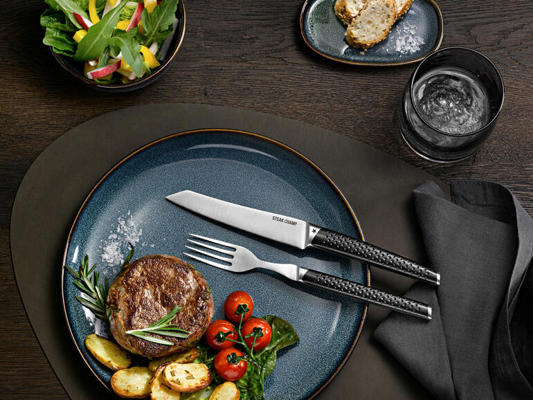 Steakbestek Prime Rib, set van 2 op een modern bord met steak en bijgerechten.