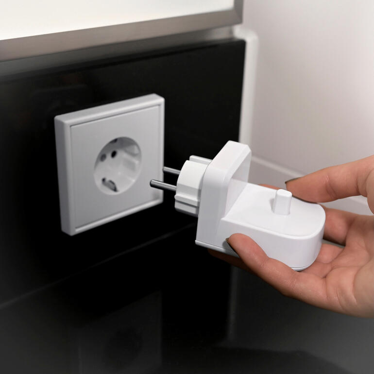Gebruiker sluit de oplaadstation voor draadloze tandenborstels aan op het stopcontact.