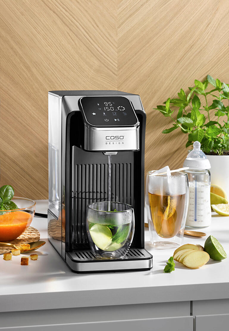 Turbo-ketel voor heet water met glazen en verse ingrediënten op tafel.