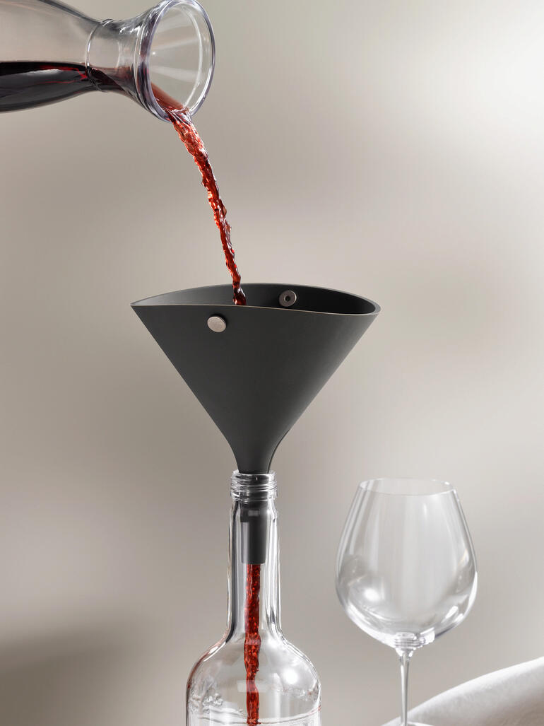 Vouwtrechter die wordt gebruikt bij het vullen van een fles met rode wijn.