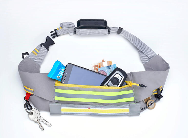 LED-heuptas met smartphone en bankbiljetten in het hoofdcompartiment.