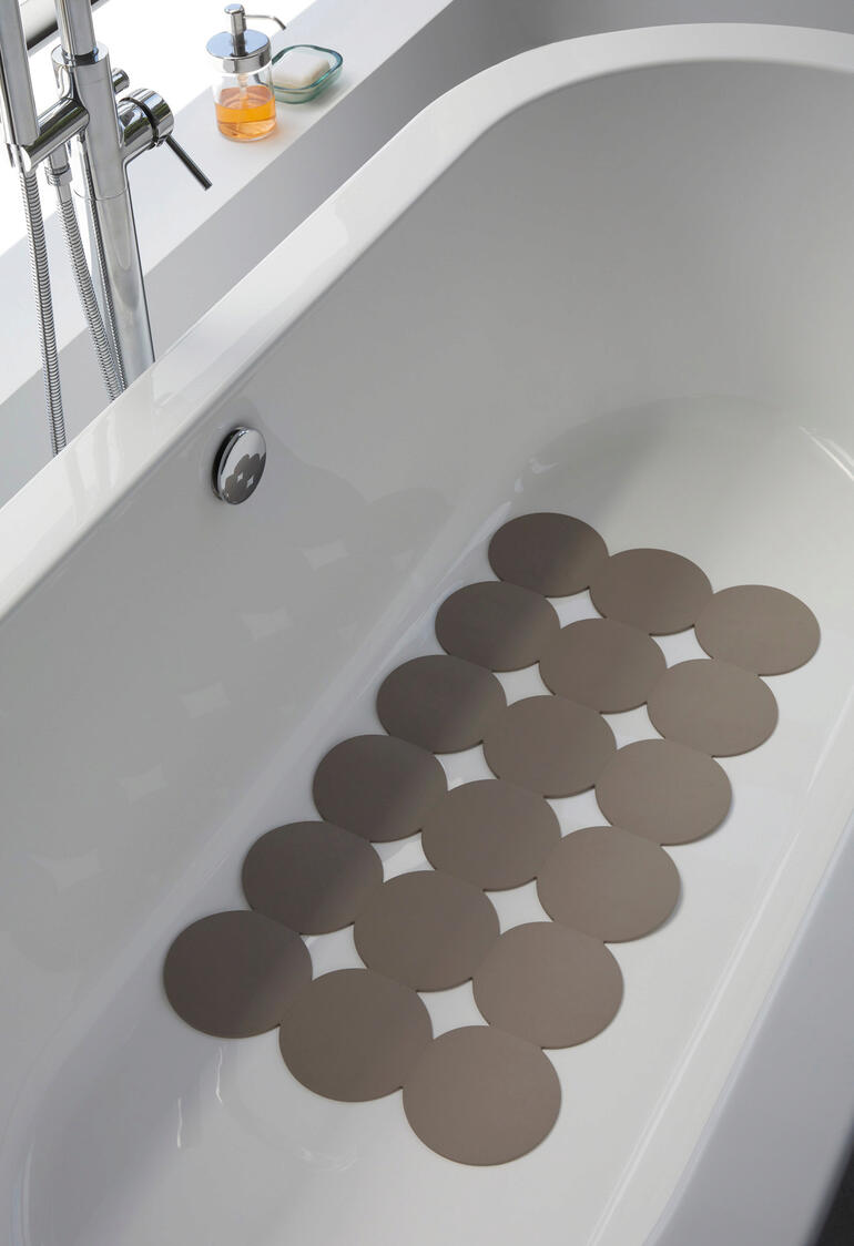badmat, taupe Antislipmat in een badkuip met rustig water.