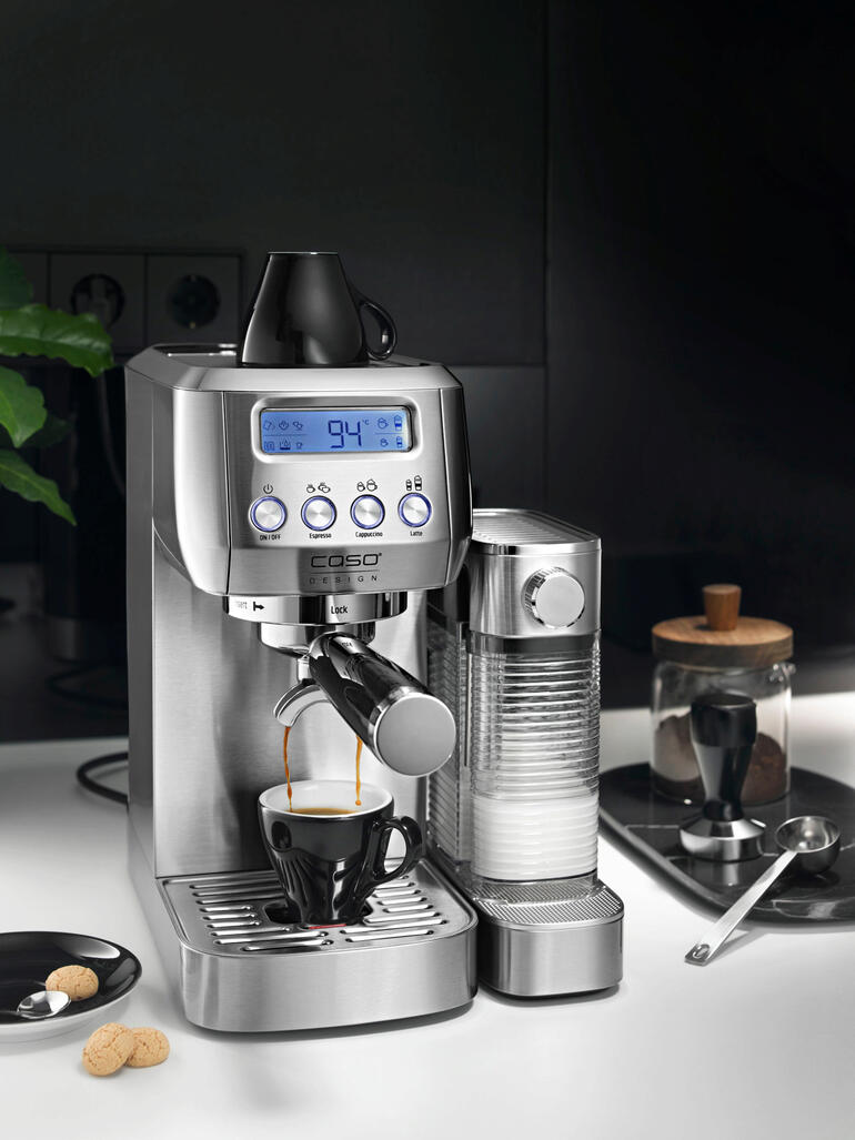 Espresso machine met digitaal display en een kopje op het aanrecht.