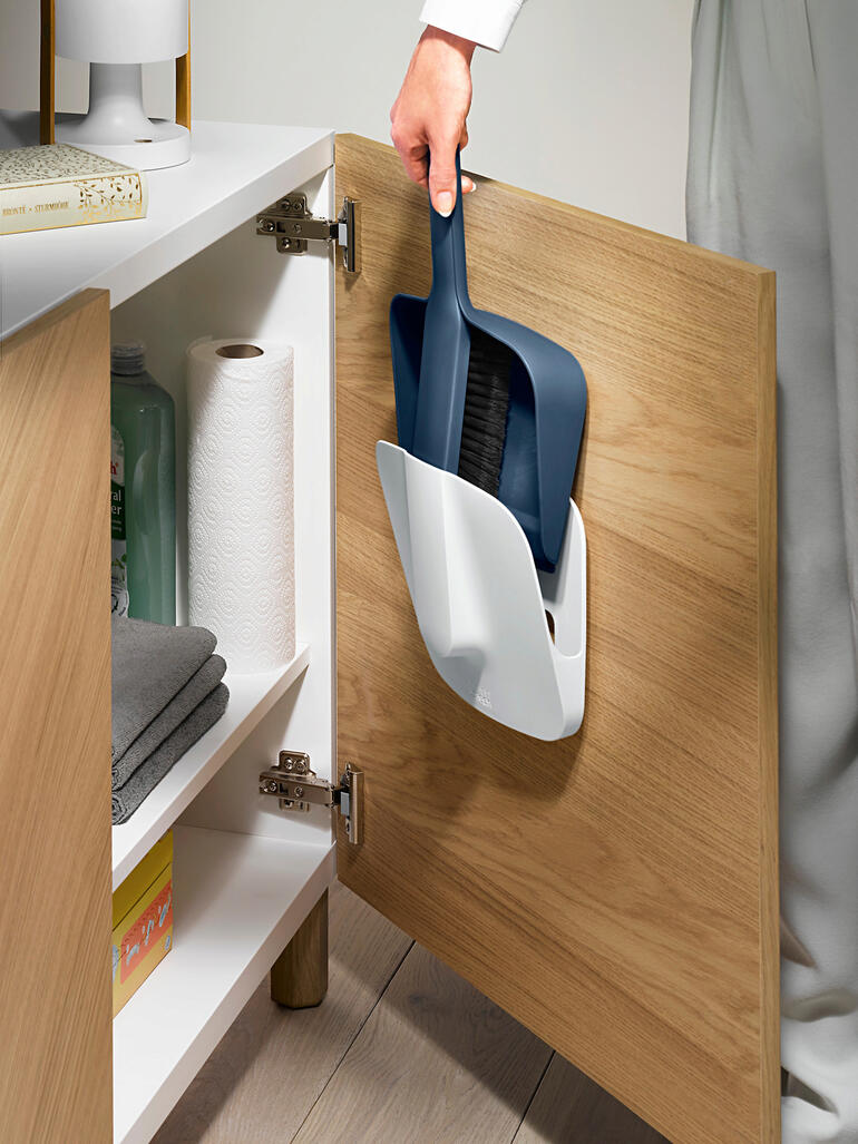 Broomset met wandhouder wordt uit een kast gehaald.