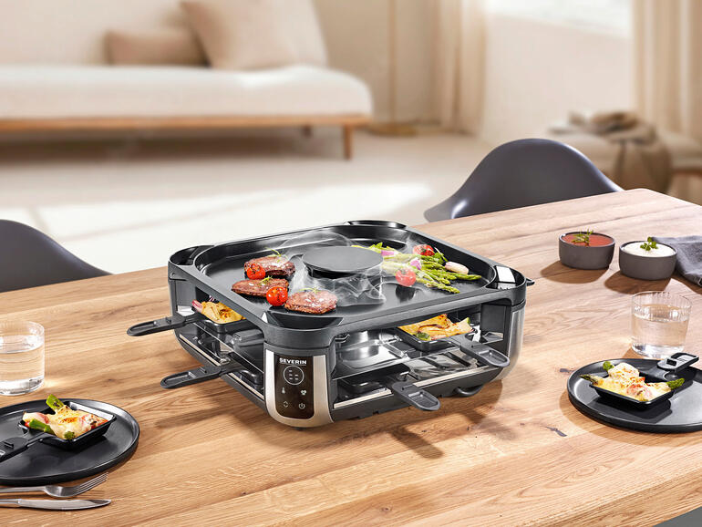 Raclette-grill met ingebouwde rookafzuiging op een gedekte tafel.