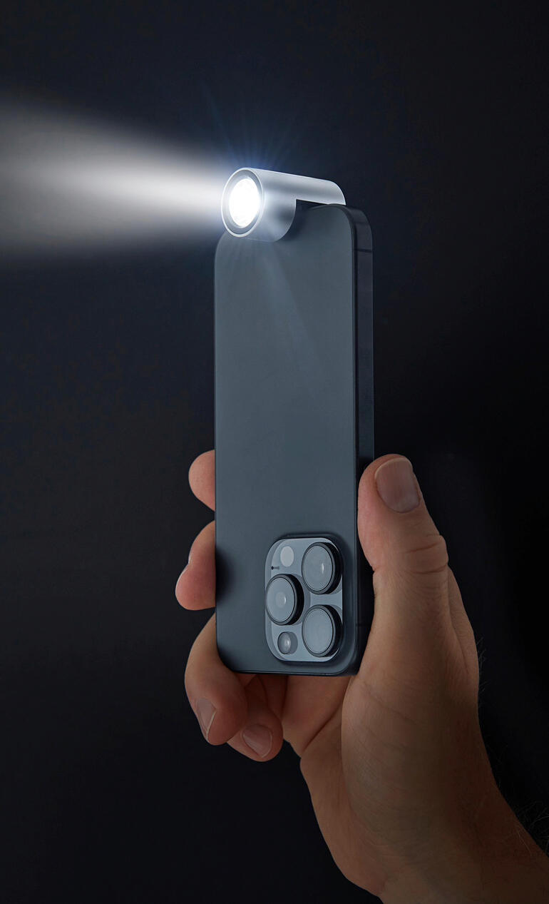 Handheld smartphone zaklamp straalt licht in donkere achtergrond
