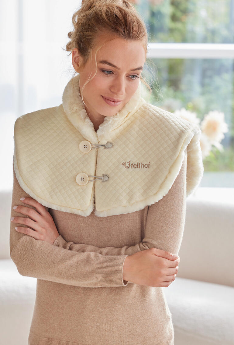 Vrouw draagt een lamswollen schouderwarmer met twee knopen