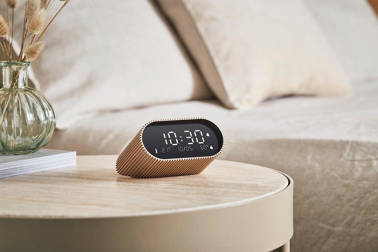 Vrouw in een zwarte plisséstola glimlachend op een plein.