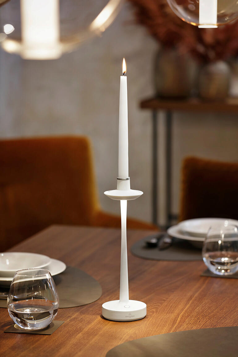 De lamp kan vrijwel overal worden gebruikt, zowel binnen als buiten. Witte 2-in-1 tafellamp op een gedekte tafel