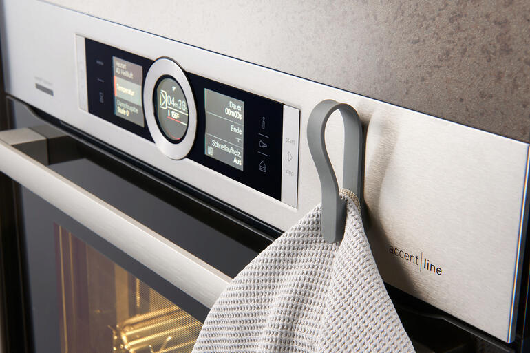 Magnetische handdoekhouders op de oven met een theedoek.