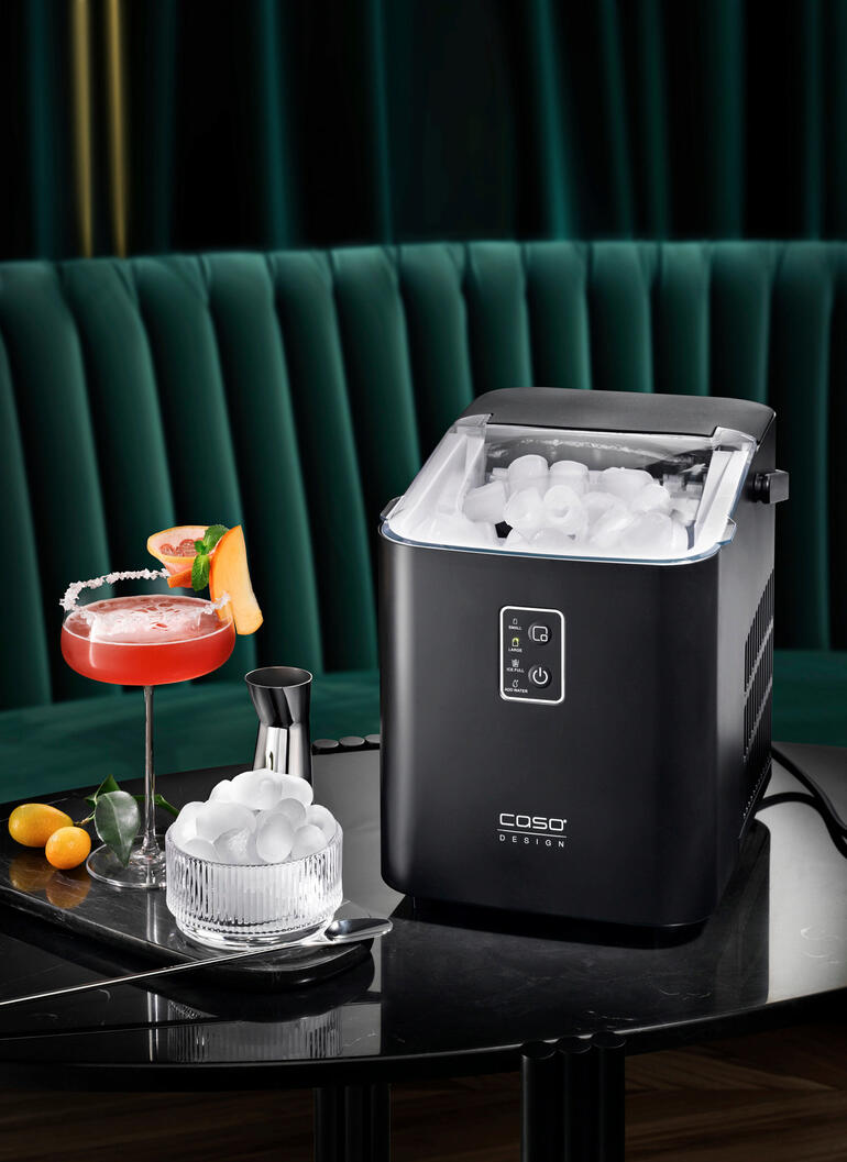 Design ijsblokjesmachine op een tafel met cocktails en ijsblokjes.