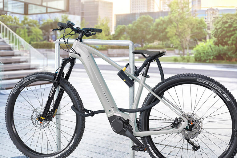 Beugelslot met veiligheidssnoer gemonteerd op een fiets.