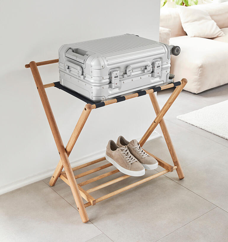 Eik kofferopslag met handbagage en schoenen op een houten frame.