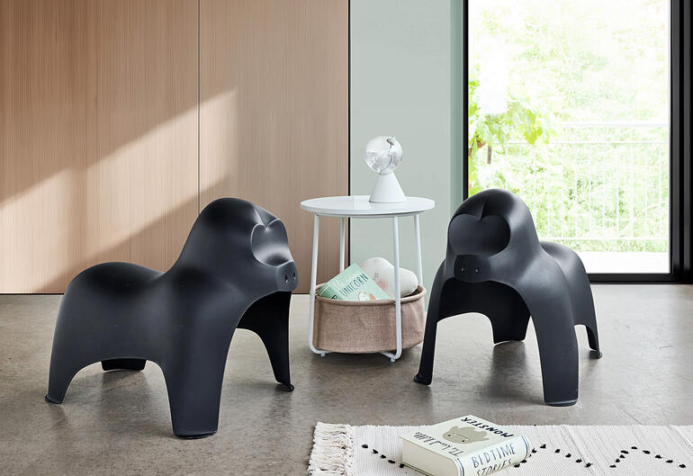 Twee zwarte gorillahockers staan in een moderne woonkamer met een tafel.
