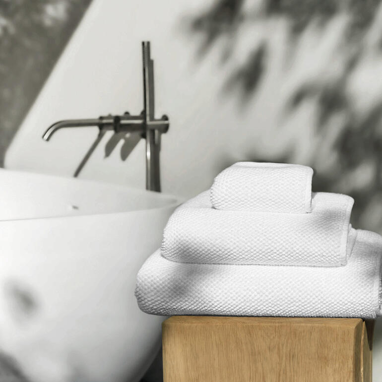 Graccioza luxe handdoeken gestapeld op een houten rek.