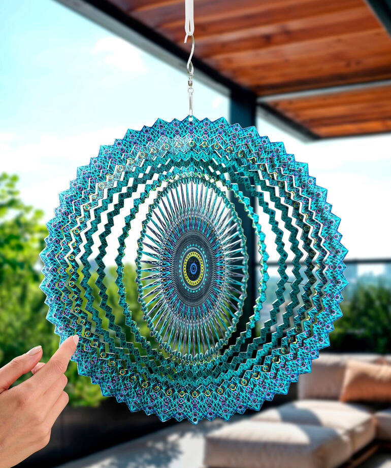 Mandala-windspel in blauwgroen, hangend in de open lucht.