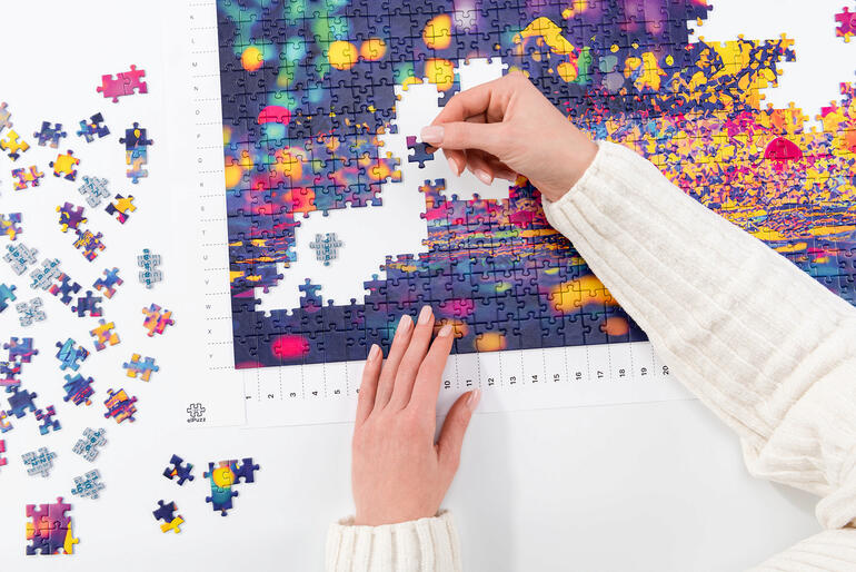 Persoon die aan een kleurrijke puzzel werkt.