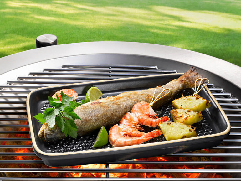 Vis en garnalen op een grillplaat buiten