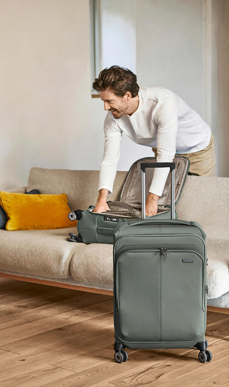 Man pakt een lichte Travelite trolley op een bank.