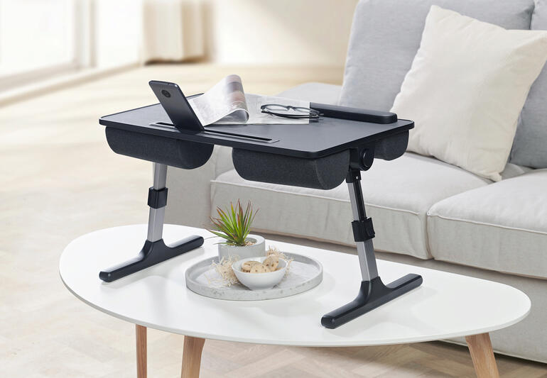 In een handomdraai wordt het laptopkussen een handige tafel. 2-in-1 laptopkussen als tafel in gebruik, met smartphone en bril.