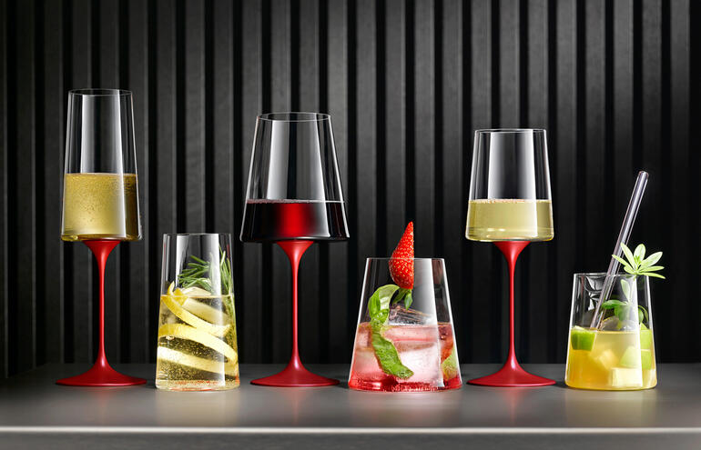 Set van twee kristallen glazen met verschillende dranken op een tafel.