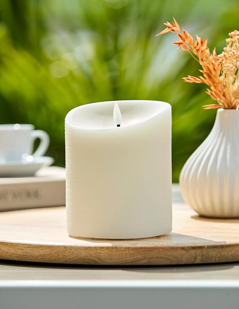 LED-wasoutdoorkaars op een houten dienblad met planten.