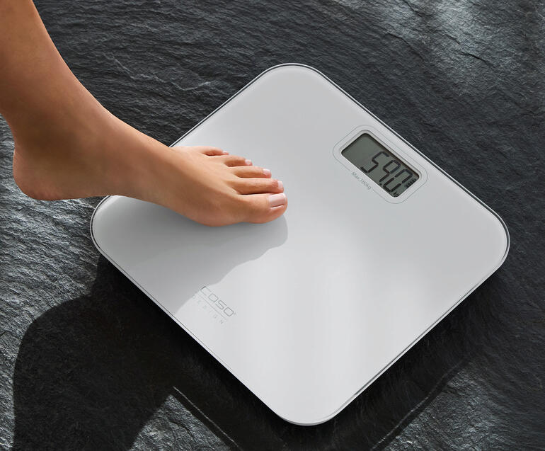 Voeten staan op een batterijloze design personenweegschaal